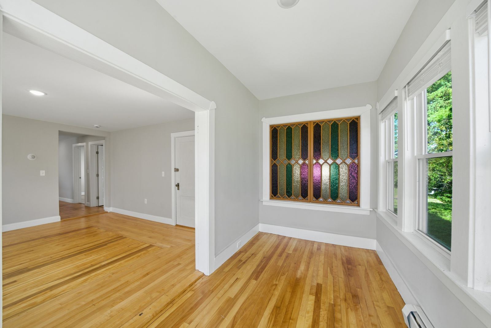 Living room with hardwood floors and a stained-glass window